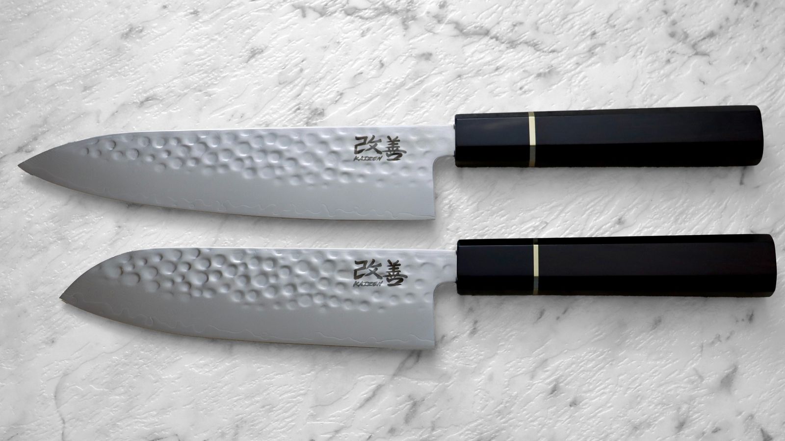Kaizen gyuto and santoku pair laid side by side on marble
